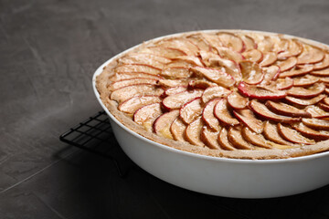 Tasty apple pie in baking dish on grey table, closeup