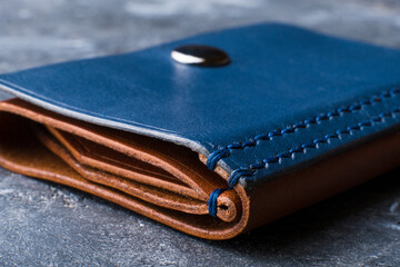 Stylish handmade men's wallet made of blue leather. Genuine leather craft. Macro shot.