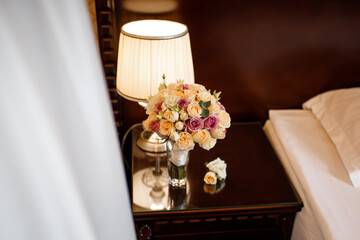 Wedding bouquet and lamp on the bedside table