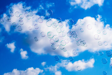 Soap bubbles on blue cloudy sky background