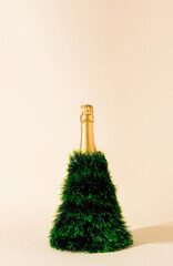 Champagne bottle Christmas tree concept. New Year party idea. Minimal holiday background.