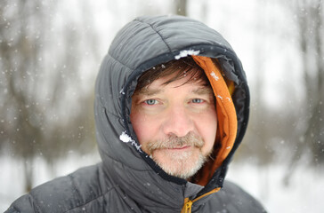 Portrait of mature man during hiking in winter forest.