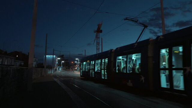 A blue tram moving into the city center at night, Montpellier - France
