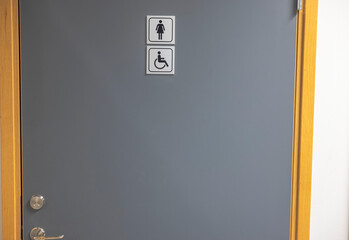 Close up view of gray door of public toilet with sign for men ,women with disability. Sweden. 