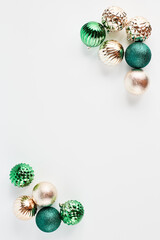 festive Christmas frame of toys in the shape of a ball of green and gold color on a white background. flat lay with place for text