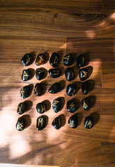 Viking ancient rune stones carved on gemstones.
Rune stone on a wooden table.