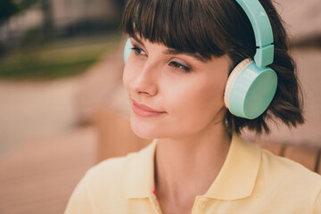 Photo of cheerful dreamy nice young woman listen music enjoy good mood smile outside outdoors city...