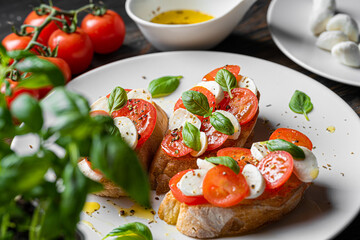 bruschetta caprese. fresh basil leaves, ripe aromatic tomatoes and Italian mozzarella on bruschetta, drizzled with olive oil and sprinkled with pepper and herbs.