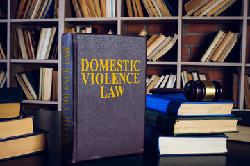 Domestic violence law, pile of books and gavel.