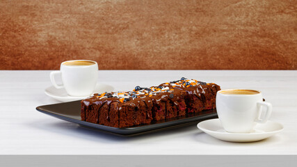 Homemade brownie and two cups of coffee espresso on white wooden table. Copyspace.