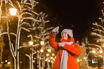 Girl in a night city snowflake Christmas city lights. Christmas and winter holidays concept.