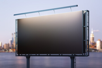 Obraz premium Blank black horizontal billboard on skyline background at evening, perspective view. Mock up, advertising concept