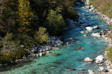  kayakers paddling on the clear turquoise waters of the Soca River in the mountains of northern...