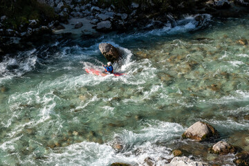  kayaker paddling on the clear turquoise waters of the Soca River in the mountains of northern Slovenia