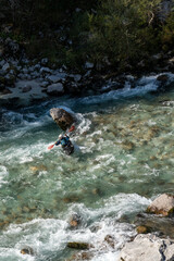  kayaker paddling on the clear turquoise waters of the Soca River in the mountains of northern Slovenia