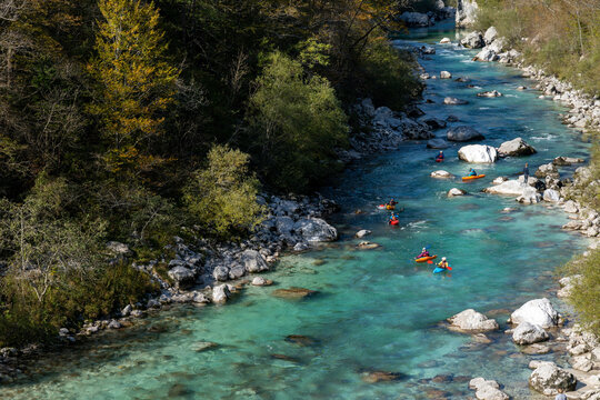  kayakers paddling on the clear turquoise waters of the Soca River in the mountains of northern Slovenia