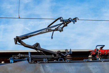 Overhead power line with sliding contactor on railway tracks. Electric train high voltage collector...