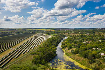 Fototapeta na wymiar Aerial view of the Solar panels on a hill above the river in Kamianka, Ukraine