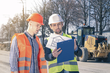 Group of construction engineers on a building plot. Engineers discussing progress of construction.
