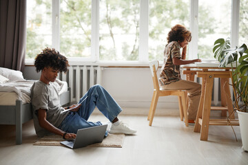 Side view portrait of African-American brother and sister studying at home together, copy space