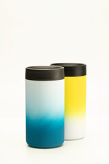 Two mugs thermos blue and yellow on a white background