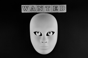 Financial fraud crime. The white mask of a fraudster. The inscription is wanted.