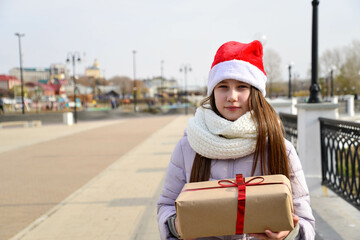 A girl holding a christmas present.