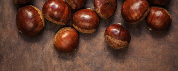 Chestnuts on on an old board with copy space. Autumn fall concept. Horse chestnuts top view.