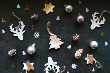 Various Christmas ornaments and colorful sequins on dark background. Flat lay.