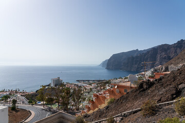 View of the Atlantic Ocean and the cliffs of Los Gigantes. The town of Puerto de Santiago is located on the coast. View from the observation deck - Mirador Archipenque. Tenerife. Canary Islands. Spain