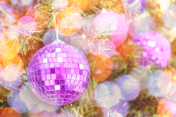 Christmas bokeh lights on a Christmas tree with purple balls background. New Year composition with copy space
