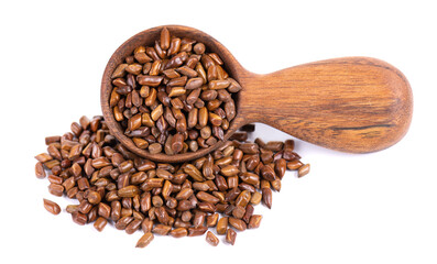 Cassia tora beans in wooden spoon, isolated on white background. Sicklepod or Senna obtusifolia. Clipping path.