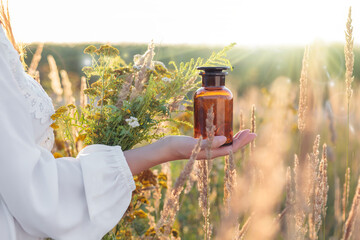 A woman holding a bottle of medication in her hand. Alternative medicine. Conceptual picture.