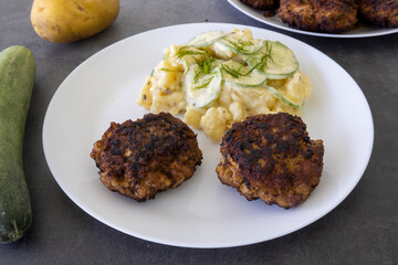 German meatballs called Frikadellen served with cucumber potato salad