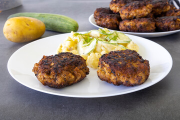 German meatballs called Frikadellen served with cucumber potato salad