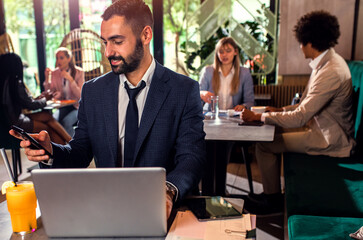 Young business man working at cafe using laptop.