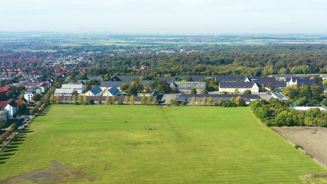 Aerial view of a huge green lawn behind a former British barracks on the outskirts of a city in Germany