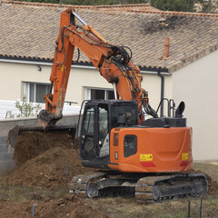 Travaux de terrassement avec une pelleteuse sur le chantier de construction d'une maison