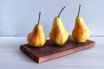 Three yellow garden ugly ripe pears on a wooden background , horizontal image.