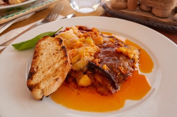 Parmigiana with aubergines and a slice of bread