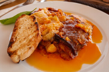 Parmigiana with aubergines and a slice of bread