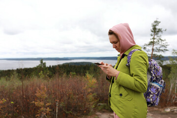 Woman with smartphone on Hiidenvuori mountain