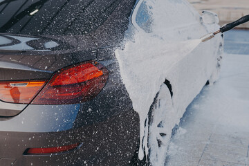 Car exterior cleaning, applying snow foam on dirty auto surface from high-pressure washer