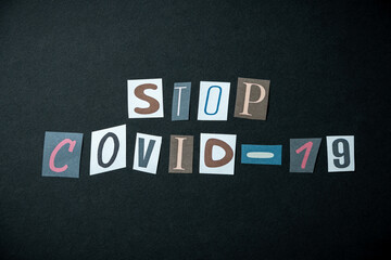 Stop COVID-19 vaccine words. Caption, heading made of letters with different fonts on a dark background.