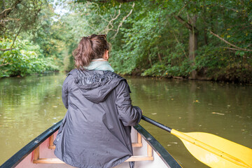 Fototapeta na wymiar Eine Frau sitzt in einem Kanu auf einem Fluss
