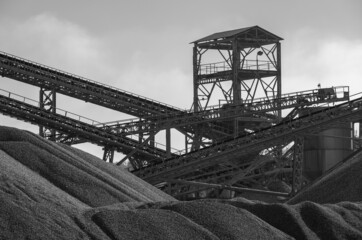 Steel tower and belt conveyors with piles of gravel. Steel structure. Gravel mining