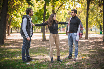 Woman with outstretched arms tries to separate men in quarrel