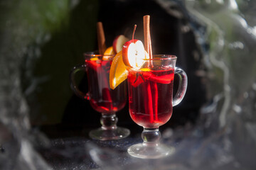Two glass glasses with mulled wine on a winter background