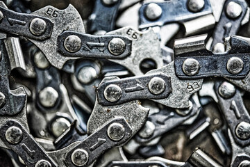 Metal chainsaw chain with sharp teeth close-up with blurred background