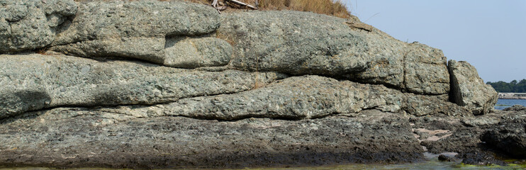 Black Sea coast. A seashore formed by frozen volcanic lava. Tectonic rocks.